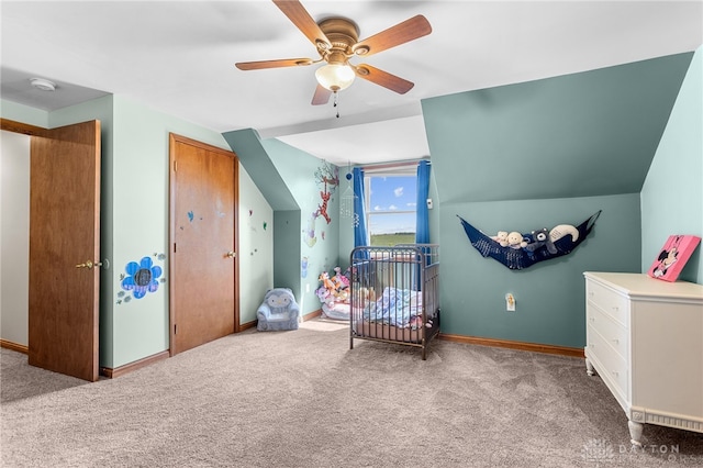 bedroom featuring lofted ceiling, carpet flooring, a crib, and ceiling fan