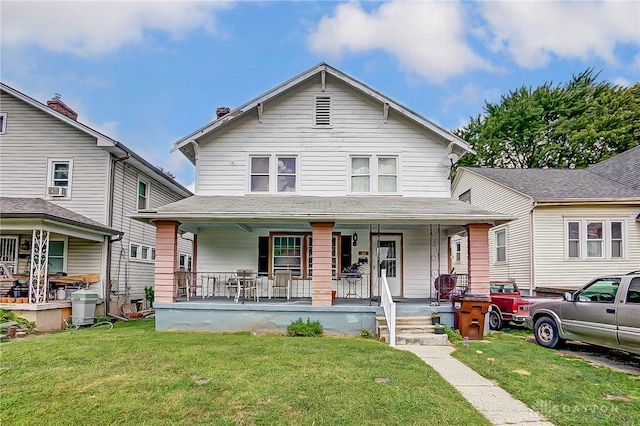 view of front of property with a front yard, cooling unit, and covered porch