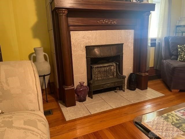 living area featuring hardwood / wood-style flooring and a tiled fireplace