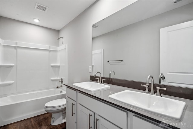 full bathroom with vanity, toilet,  shower combination, and wood-type flooring