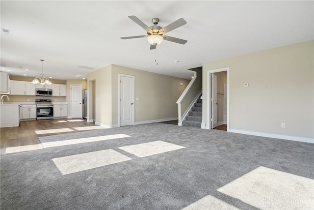 unfurnished living room featuring light colored carpet and ceiling fan