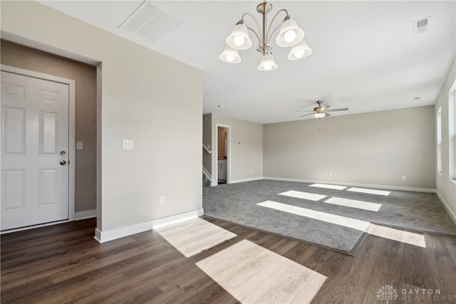 empty room with ceiling fan with notable chandelier and dark hardwood / wood-style flooring