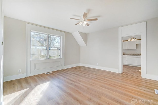 additional living space with light hardwood / wood-style floors and ceiling fan