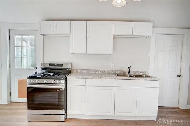 kitchen with white cabinetry, light wood-type flooring, stainless steel range with gas cooktop, and sink