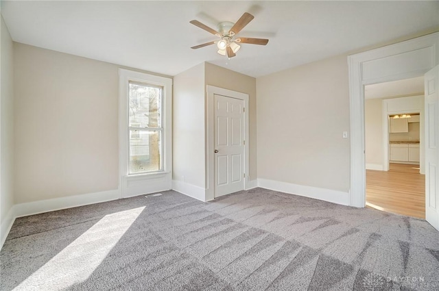 unfurnished bedroom with ceiling fan and carpet