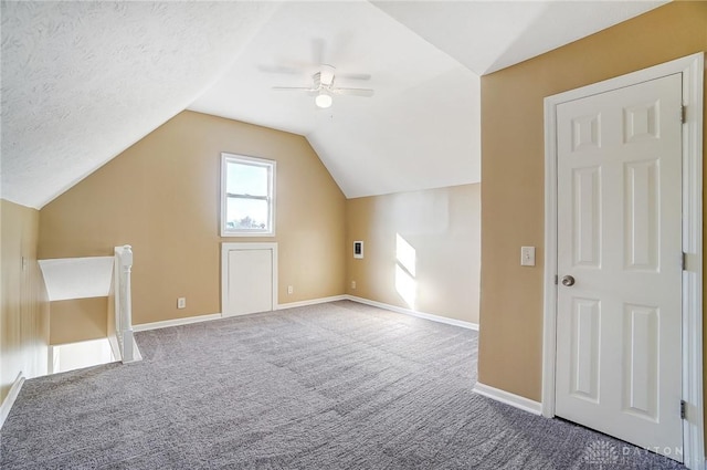 additional living space featuring a textured ceiling, ceiling fan, lofted ceiling, and carpet floors