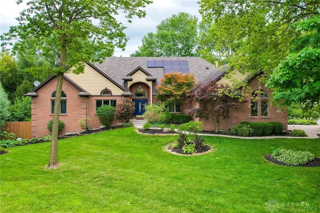 view of front of home featuring a front yard and solar panels