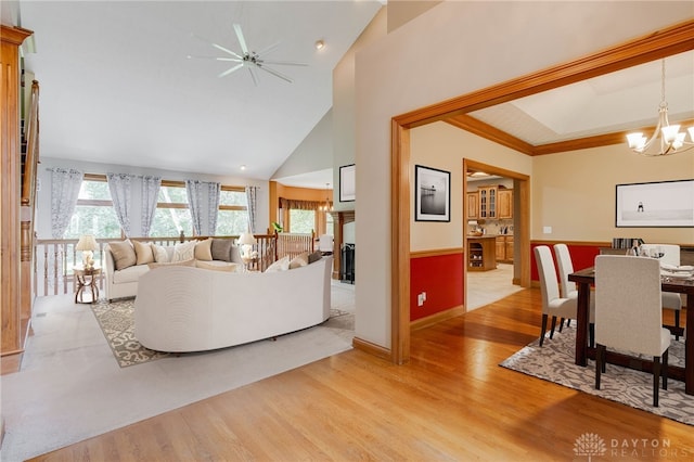 living room featuring a notable chandelier, high vaulted ceiling, and light hardwood / wood-style floors