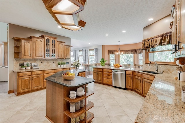 kitchen with sink, a healthy amount of sunlight, dishwasher, and light stone countertops