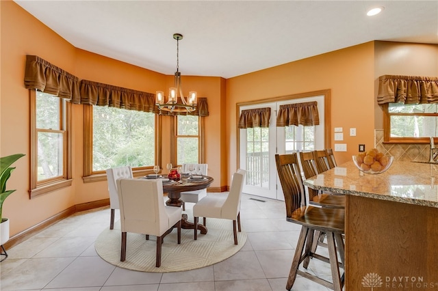 tiled dining area featuring a wealth of natural light and a chandelier