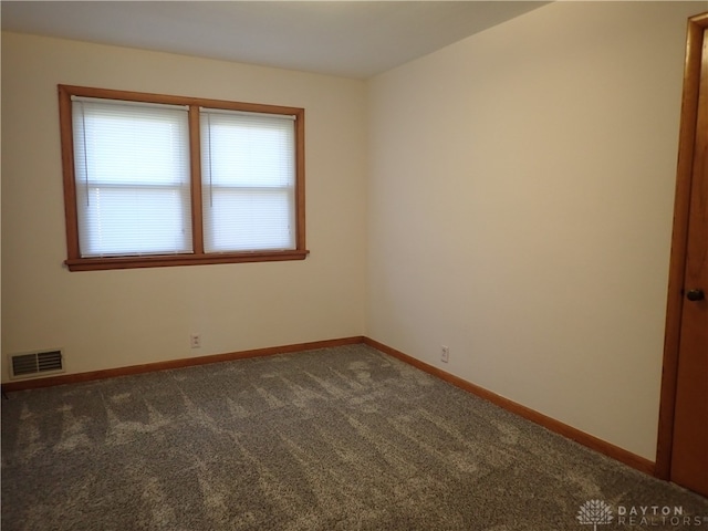 unfurnished room featuring dark carpet