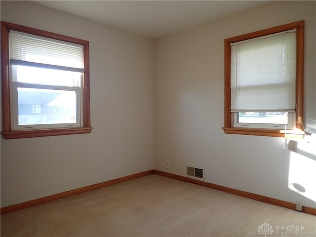 carpeted spare room with a healthy amount of sunlight