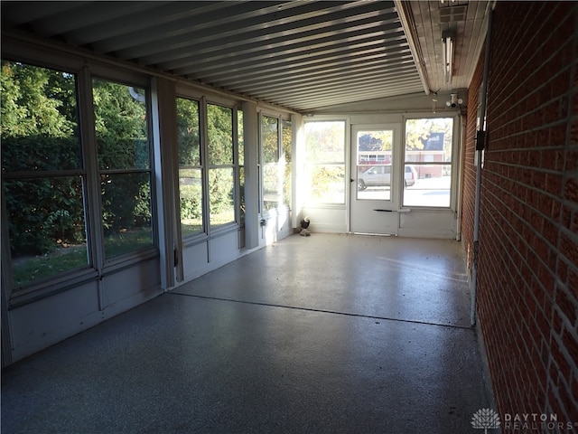 unfurnished sunroom featuring vaulted ceiling