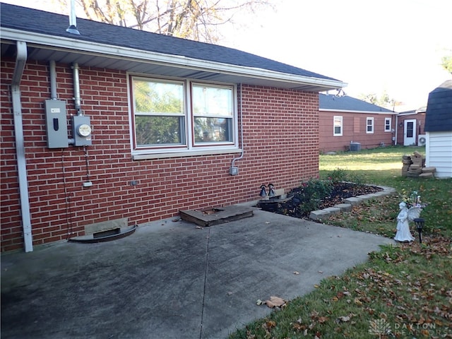 view of property exterior with a patio area and a lawn