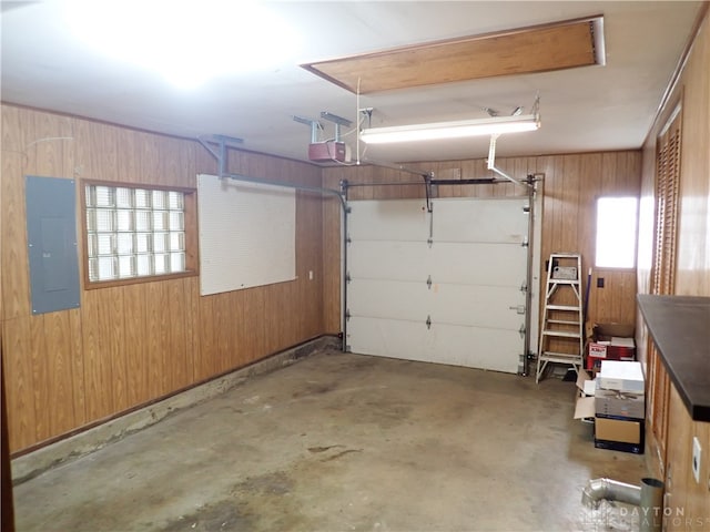 garage featuring wood walls, a garage door opener, and electric panel