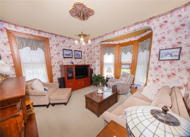 carpeted living room with an inviting chandelier