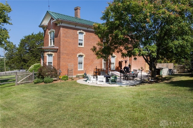 back of property with a lawn and a patio area