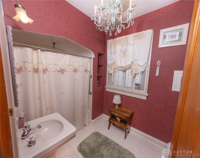 bathroom featuring tile patterned flooring, a notable chandelier, and sink