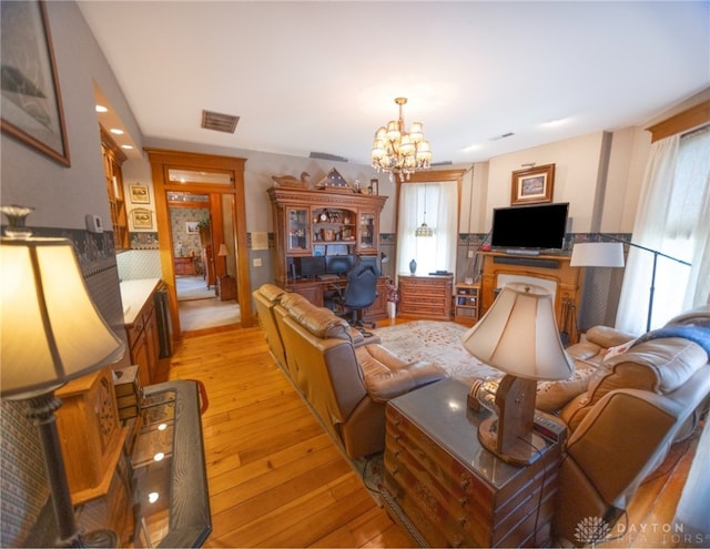 living room featuring light wood-type flooring and a notable chandelier