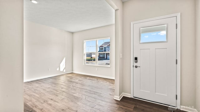 entryway featuring dark hardwood / wood-style flooring and a textured ceiling