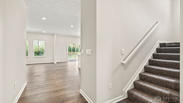 stairs featuring hardwood / wood-style flooring and a textured ceiling