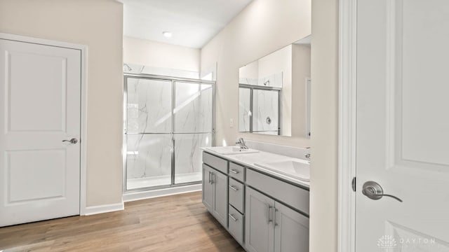 bathroom with hardwood / wood-style floors, vanity, and walk in shower