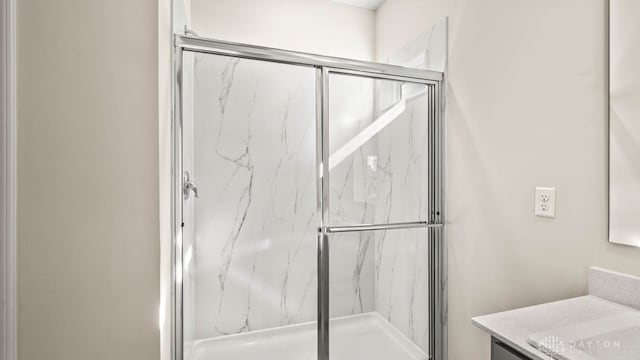 bathroom featuring vanity and a shower with shower door