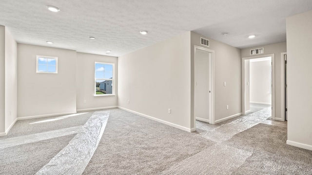 empty room featuring light carpet and a textured ceiling