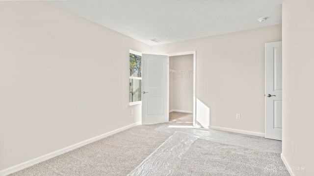 unfurnished bedroom featuring light carpet and a closet