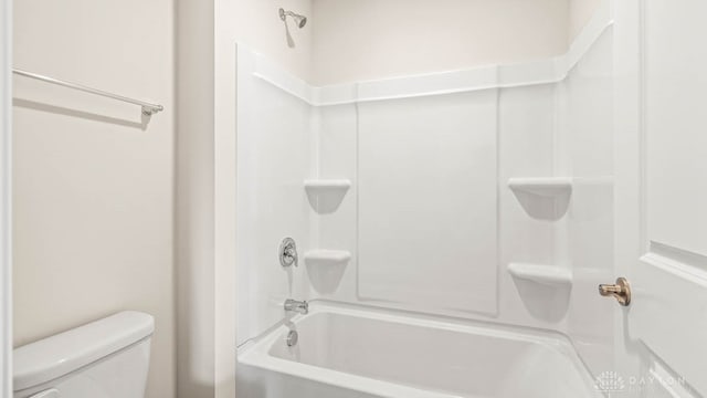 bathroom featuring shower / tub combination and toilet