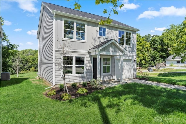 view of front of house featuring a front yard, a garage, and central AC unit