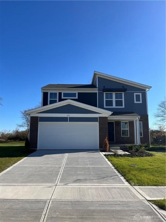 view of property featuring a garage and a front lawn