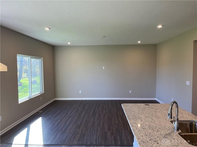 interior space with dark hardwood / wood-style flooring, sink, and a textured ceiling