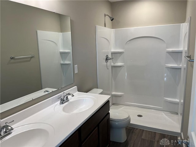 bathroom with vanity, toilet, wood-type flooring, and walk in shower