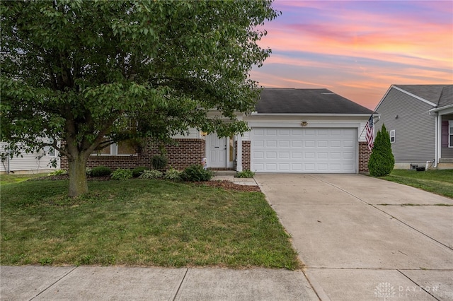 view of front of home with a garage and a yard