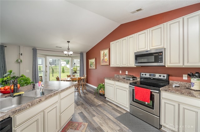 kitchen with wood-type flooring, sink, an inviting chandelier, lofted ceiling, and stainless steel appliances