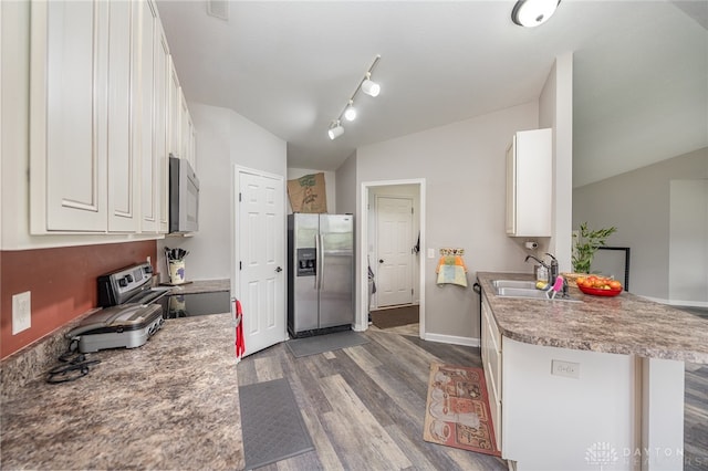 kitchen with appliances with stainless steel finishes, rail lighting, dark hardwood / wood-style floors, sink, and white cabinets