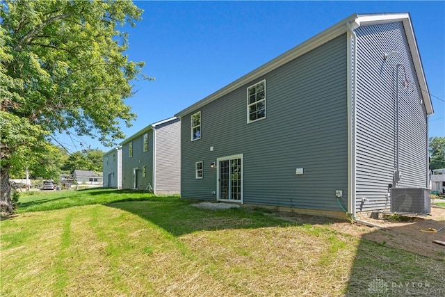 back of house with a yard and central air condition unit