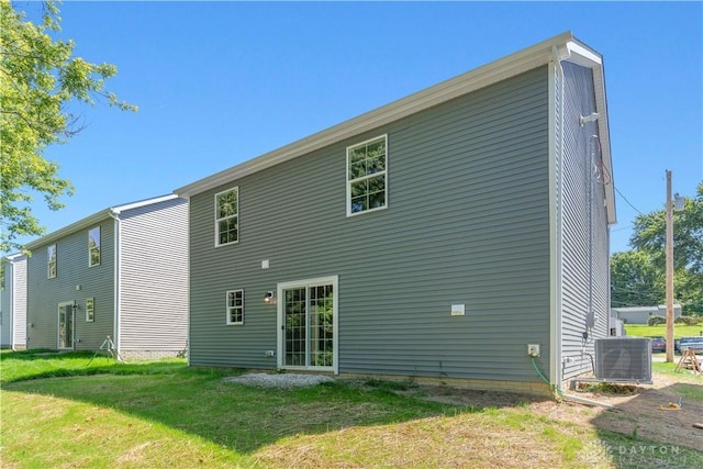 back of house with central AC and a yard