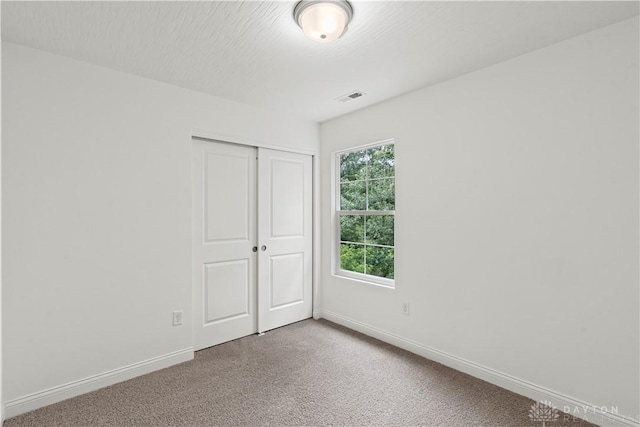 unfurnished bedroom with carpet floors and a closet