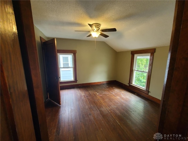 additional living space featuring ceiling fan, lofted ceiling, dark hardwood / wood-style flooring, and a textured ceiling