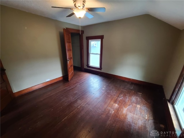 unfurnished room featuring vaulted ceiling, ceiling fan, and dark hardwood / wood-style flooring