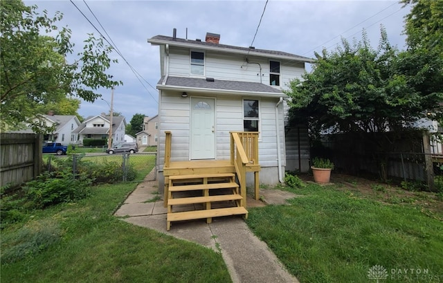 rear view of property featuring a yard