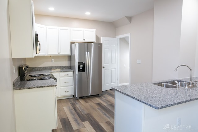 kitchen with appliances with stainless steel finishes, hardwood / wood-style floors, sink, light stone counters, and white cabinets