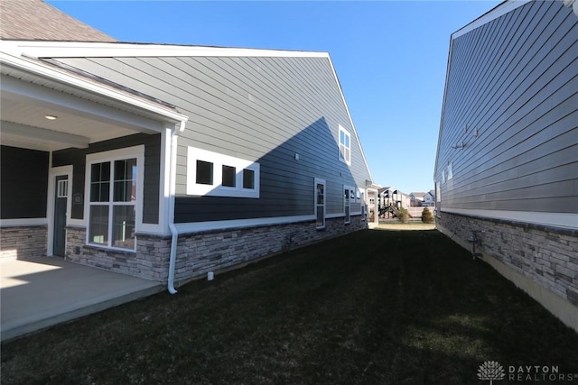 view of side of property with a lawn and a patio area