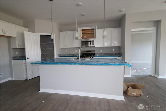 kitchen with pendant lighting, sink, an island with sink, appliances with stainless steel finishes, and white cabinetry