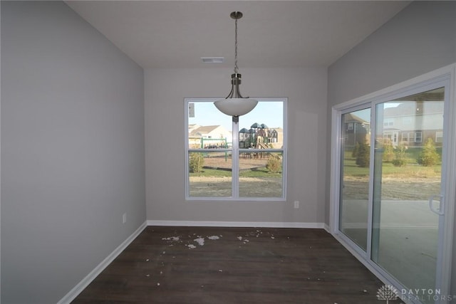 unfurnished dining area with dark wood-type flooring