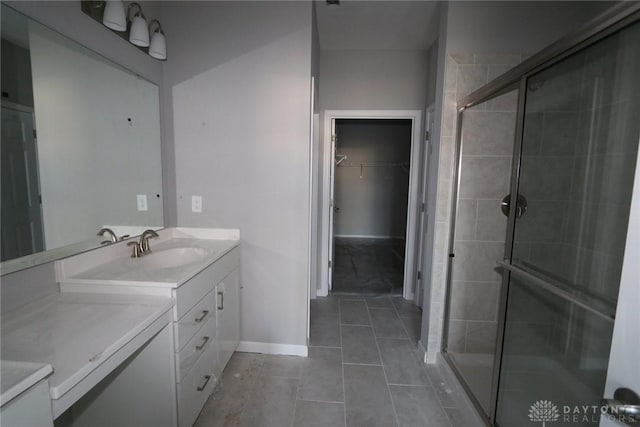 bathroom featuring tile patterned flooring, vanity, and a shower with shower door