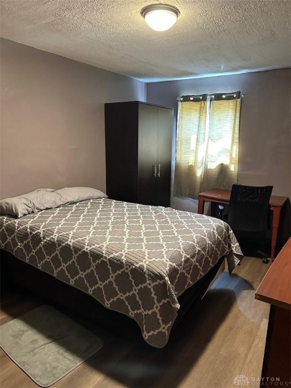 bedroom featuring hardwood / wood-style flooring and a textured ceiling