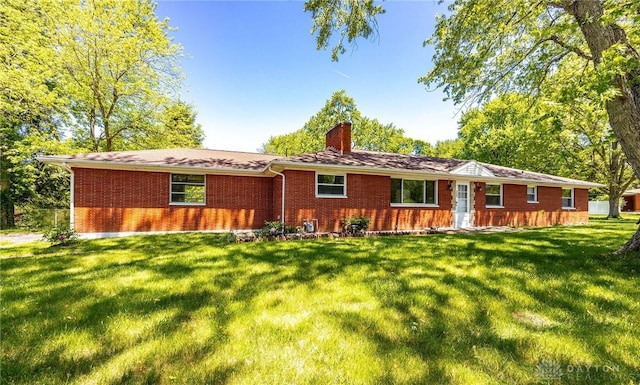 rear view of property featuring a lawn